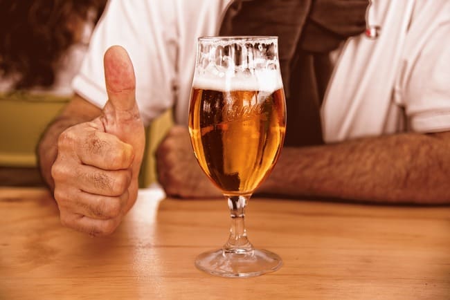 hombre bebiéndose una cerveza de barril en un bar